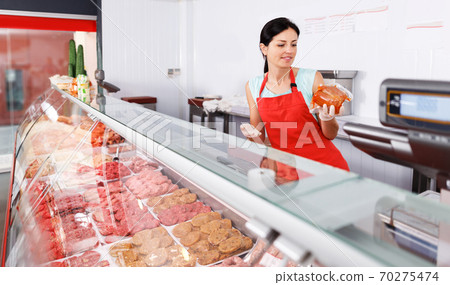 woman seller showing different sausages 70275474