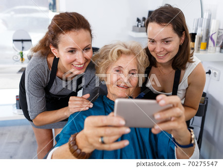 Hairdressers wit senior woman client making selfie 70275547