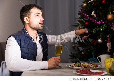 Male celebrate the New Year with champagne and watching tv 70275752