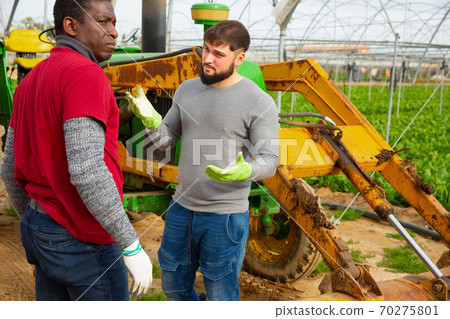 Worried grower talking to African American friend Worried grower talking to African American friend 70275801