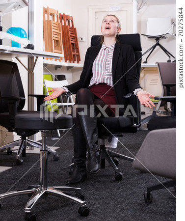 Happy girl in office chair in store Happy girl in office chair in store 70275844