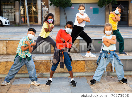 Kids in masks dancing on street 70275908