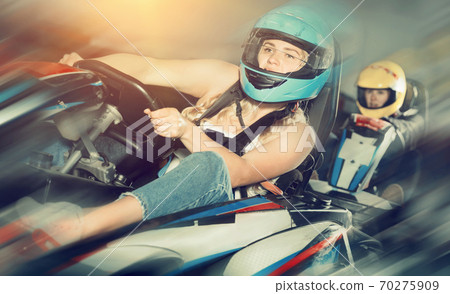 Female racer in helmet driving kart on track Female racer in helmet driving kart on track 70275909