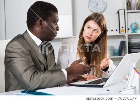 Focused coworkers working together 70276177