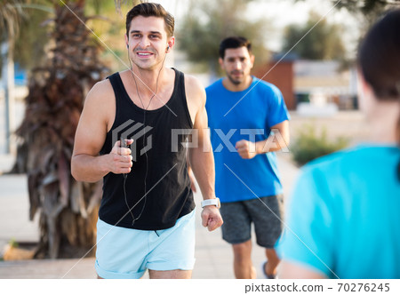 Portrait of adult man who is jogging with friend Portrait of adult man who is jogging with friend 70276245