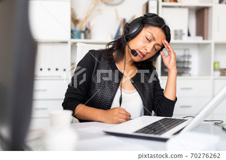 Tired female customer service agent during work 70276262