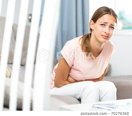 Unhappy female having stomachache Unhappy female having stomachache 70276368