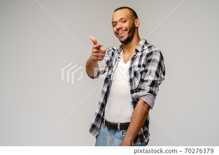african-american young man wearing casual shirt and showing thumbs up over light grey background african-american young man wearing casual shirt and showing thumbs up over light grey background 70276379