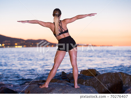 Adult woman is practicing stretching Adult woman is practicing stretching 70276407
