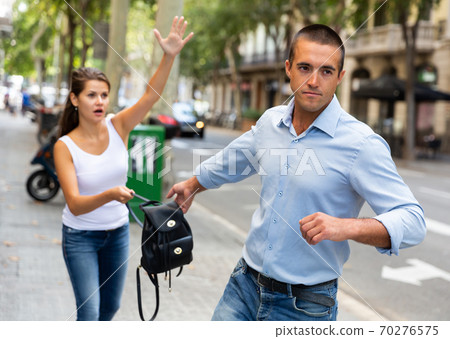 Street robbery pulling woman backpack Street robbery pulling woman backpack 70276575