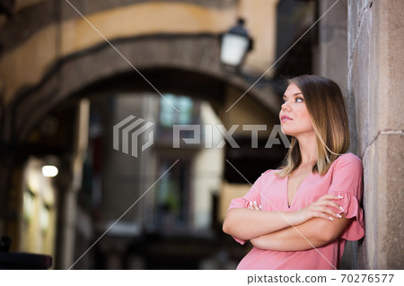 Young thoughtful woman near the stone wall in historical center Young thoughtful woman near the stone wall in historical center 70276577
