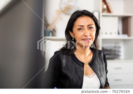 Portrait of smiling hispanic female office employee Portrait of smiling hispanic female office employee 70276584