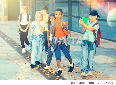 Tween boys and girls with backpacks walking to shool Tween boys and girls with backpacks walking to shool 70276595