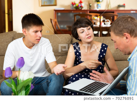 Upset woman and her son are talking to the collector 70276891