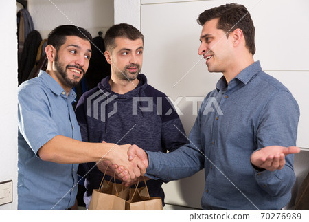 Man meeting male friends at home 70276989