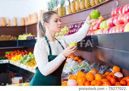Pretty female in apron fresh apples and fruits Pretty female in apron fresh apples and fruits 70277022
