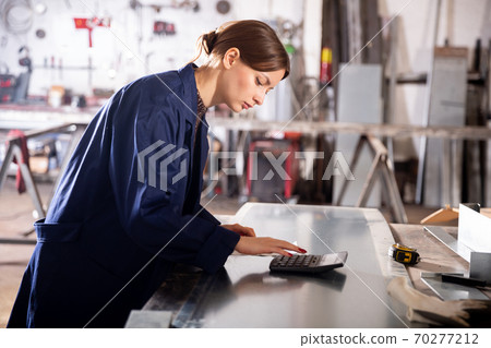 Young woman engineer calculation of material costs Young woman engineer calculation of material costs 70277212