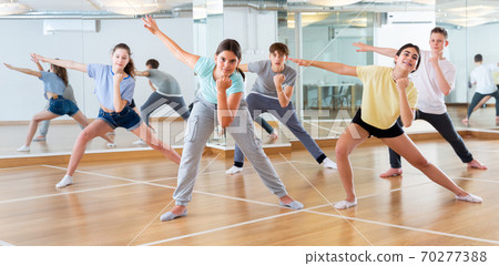 Positive smiling slim teenagers dancing hip hop in class Positive smiling slim teenagers dancing hip hop in class 70277388