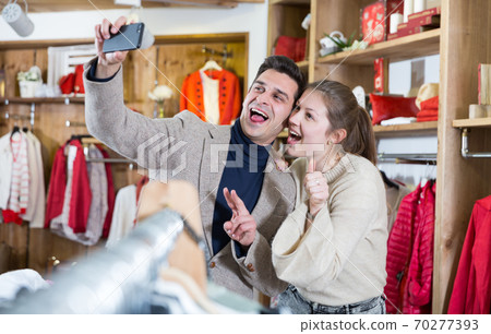 Couple is satisfied shopping and taking selfie 70277393