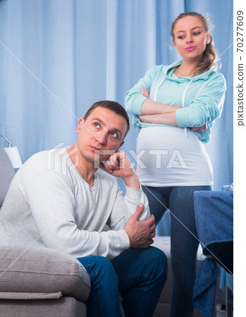 Husband and pregnant wife arguing at home 70277609