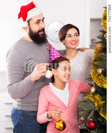 Family decorating Christmas tree 70277866