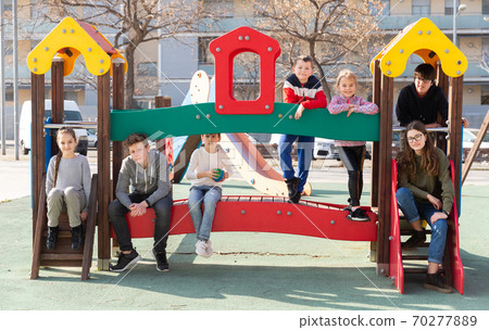 Seven children posing together on jungle gym 70277889