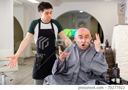 Angry man shocked by haircut in barbershop Angry man shocked by haircut in barbershop 70277922