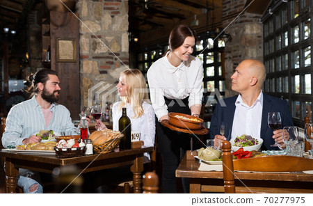Female owner of rustic restaurant serving guests Female owner of rustic restaurant serving guests 70277975