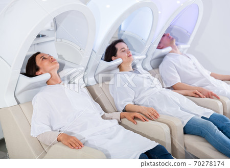 Clients of beauty salon relaxing on massaging chairs Clients of beauty salon relaxing on massaging chairs 70278174