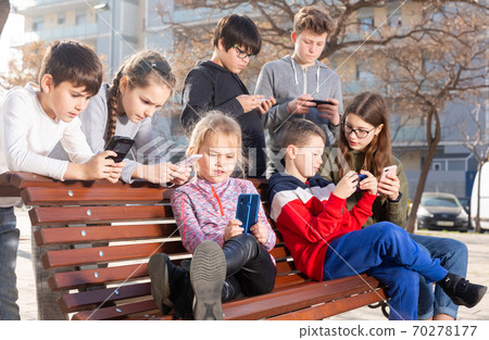 Children addicted in their phones outdoors Children addicted in their phones outdoors 70278177