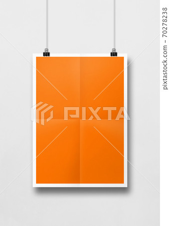 Orange folded poster hanging on a white wall with clips Orange folded poster hanging on a white wall with clips 70278238