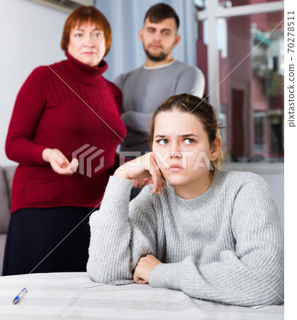 Upset woman during quarrel with family 70278511
