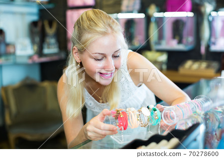 girl choosing bracelet in bijouterie shop. girl choosing bracelet in bijouterie shop. 70278600