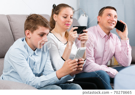 Parents and son using phones Parents and son using phones 70278665