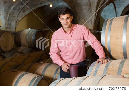 Man posing in winery cellar 70278678