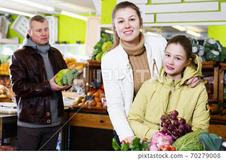 girl with mother choosing fresh ripe fruits girl with mother choosing fresh ripe fruits 70279008