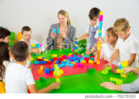 Kids with teacher playing with building blocks 70279193