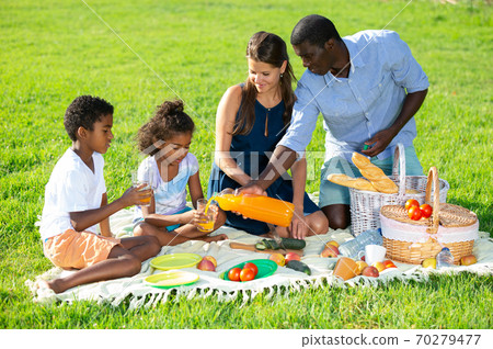 Parents with daughter and son at picnic Parents with daughter and son at picnic 70279477