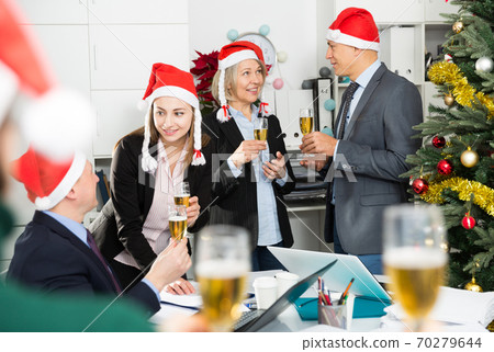 Colleagues celebrating Christmas in office Colleagues celebrating Christmas in office 70279644