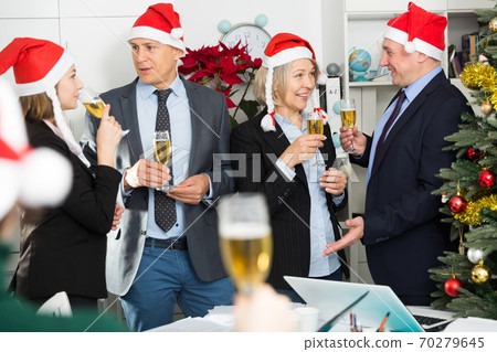 Colleagues celebrating Christmas in office Colleagues celebrating Christmas in office 70279645
