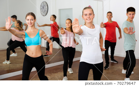 Teenagers exercising with coach in choreography class Teenagers exercising with coach in choreography class 70279647
