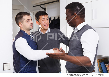 Adult male is welcoming his friends who visit him Adult male is welcoming his friends who visit him 70279919