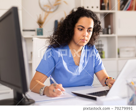 Female doctor working on laptop in office Female doctor working on laptop in office 70279991