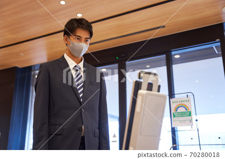 A man measuring the temperature with a non-contact thermometer 70280018