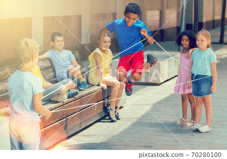 Happy smiling little friends playing with chinese jumping rope Happy smiling little friends playing with chinese jumping rope 70280100