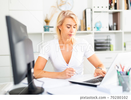 Successful business woman using laptop at workplace Successful business woman using laptop at workplace 70280102