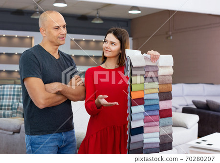 Client consulting with female shopper about choosing furniture in shop Client consulting with female shopper about choosing furniture in shop 70280207