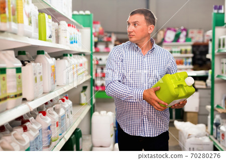 Buyer chooses finishing materials in hardware store Buyer chooses finishing materials in hardware store 70280276