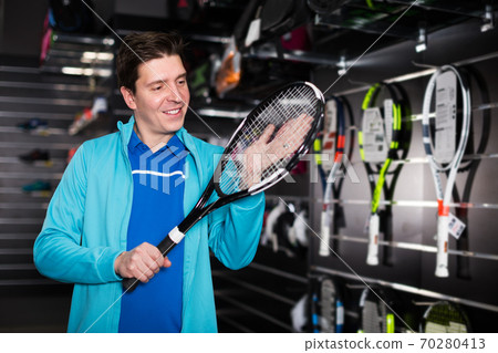 Man choosing new tennis rocket 70280413