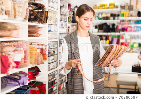 Seamstress looking for ribbons in haberdasher shop Seamstress looking for ribbons in haberdasher shop 70280597